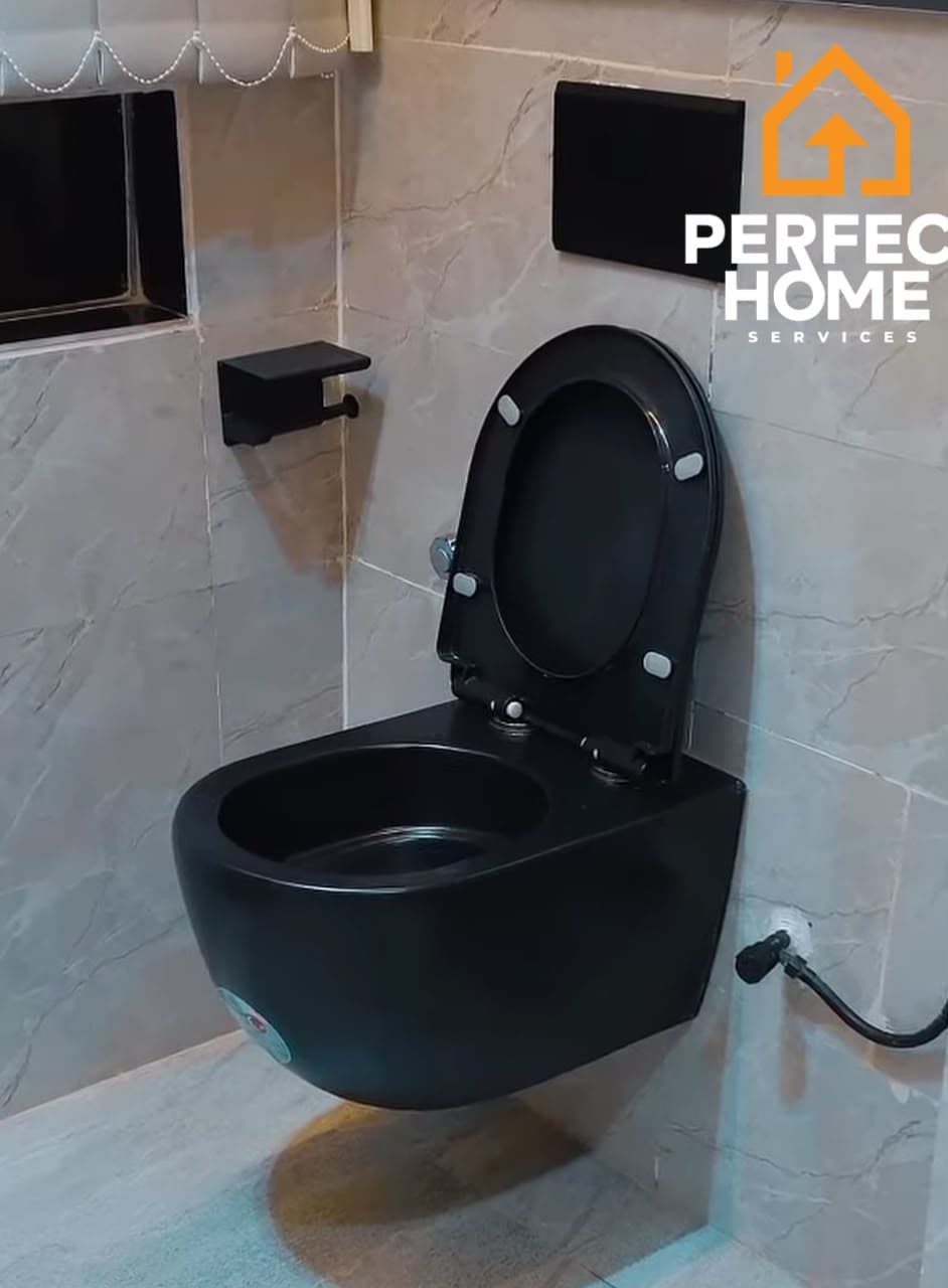Modern black wall-mounted toilet with matching black fixtures and marble-effect bathroom tiles.